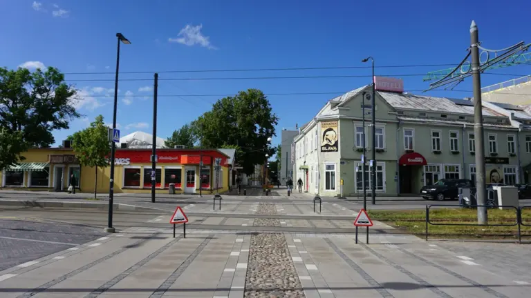 Saulaina pilsētas iela ar vēsturiskām ēkām Preiļos, Latvijā, skaidrā vasaras dienā.