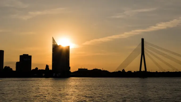 Saulriets pār Rīgas panorāmu ar Vanšu tiltu un Daugavu fonā